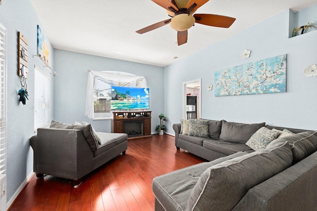 living room featuring ceiling fan and dark hardwood / wood-style floors