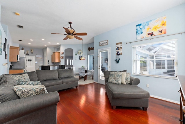 living room featuring ceiling fan and dark hardwood / wood-style flooring