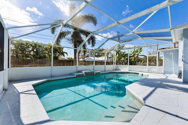 view of pool featuring glass enclosure and a patio