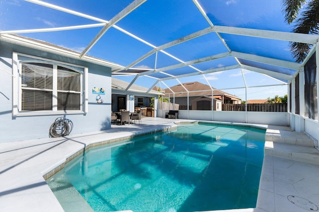 view of pool with glass enclosure and a patio area