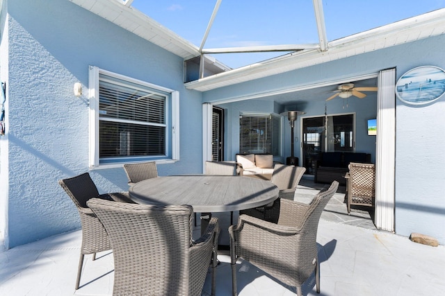 view of patio / terrace featuring ceiling fan and glass enclosure