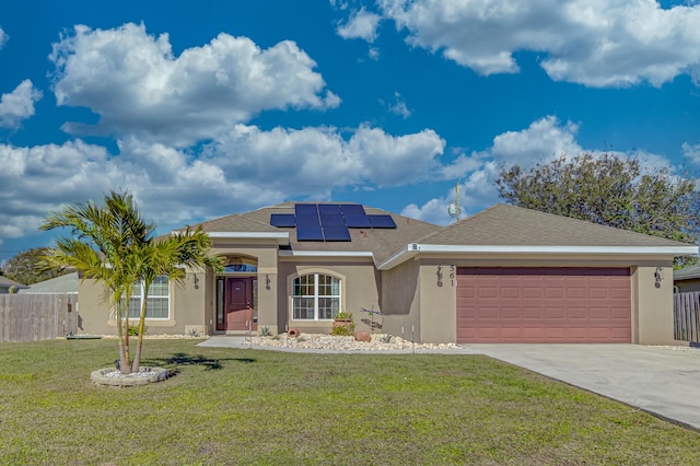 view of front of home featuring a garage, a front yard, and solar panels