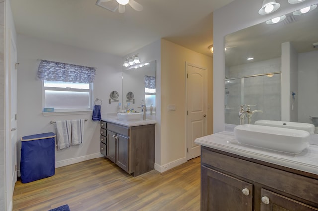 bathroom featuring ceiling fan, hardwood / wood-style floors, vanity, and a shower with door