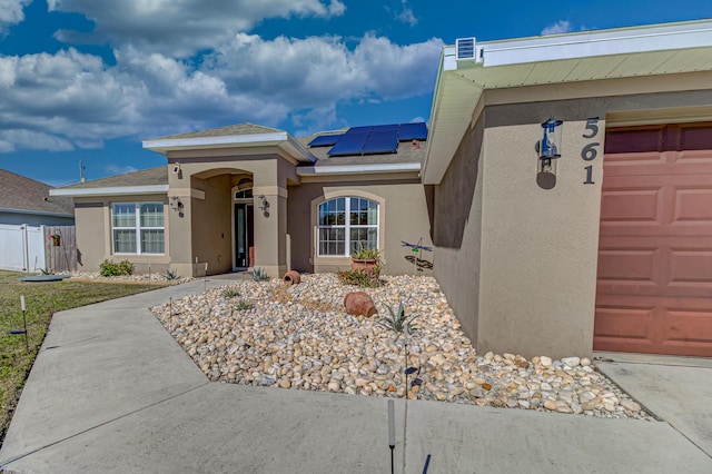 view of front facade with solar panels and a garage