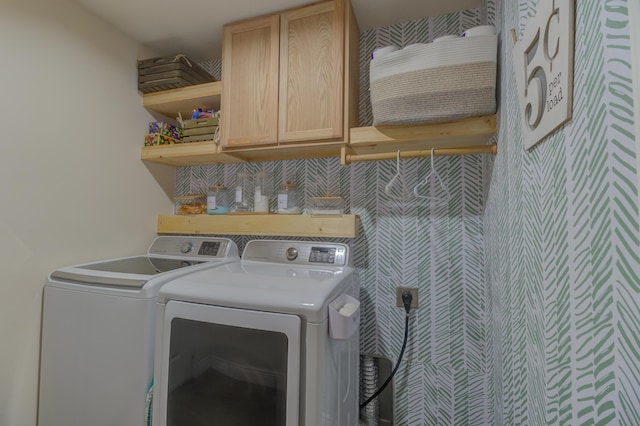 washroom featuring cabinets and washing machine and clothes dryer