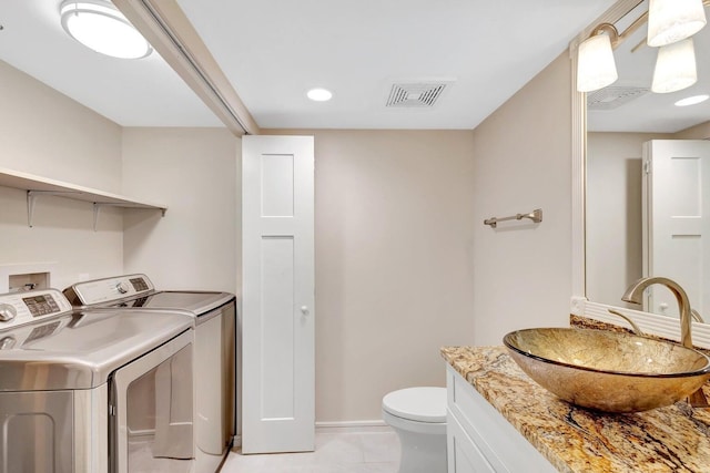 interior space with light tile patterned floors, independent washer and dryer, and sink