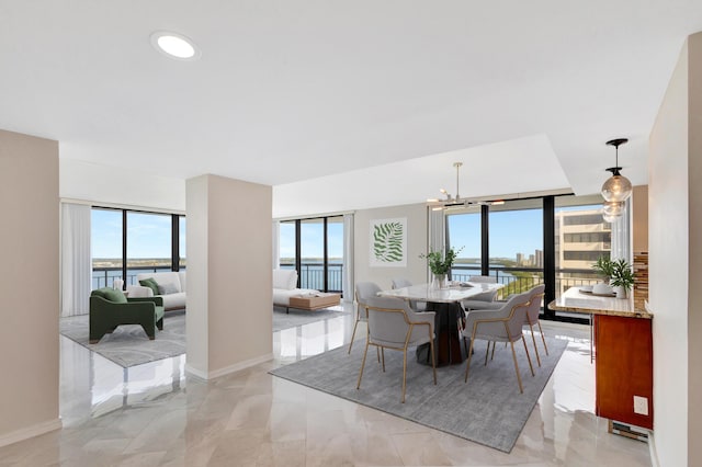 dining space with a wealth of natural light, a water view, and a notable chandelier