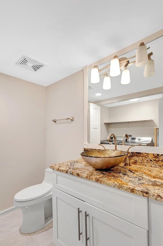 bathroom featuring toilet, vanity, and tile patterned flooring