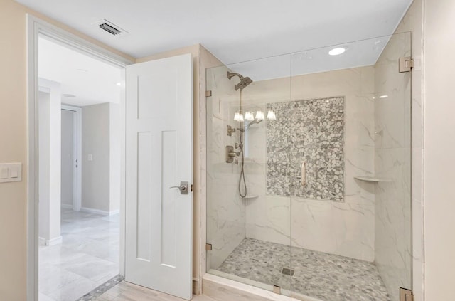 bathroom featuring walk in shower and an inviting chandelier