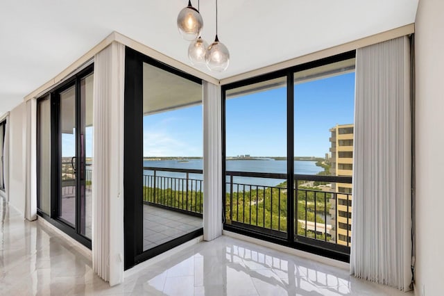 interior space featuring a water view and expansive windows