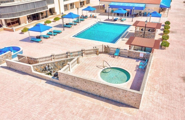 view of swimming pool with a community hot tub and a patio