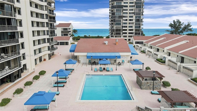 view of pool with a water view and a patio