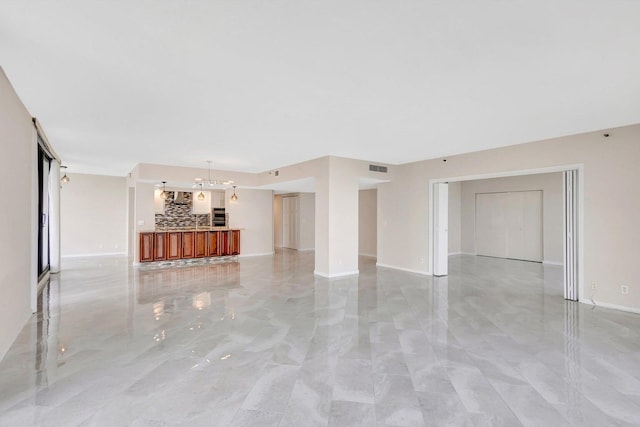 unfurnished living room with an inviting chandelier