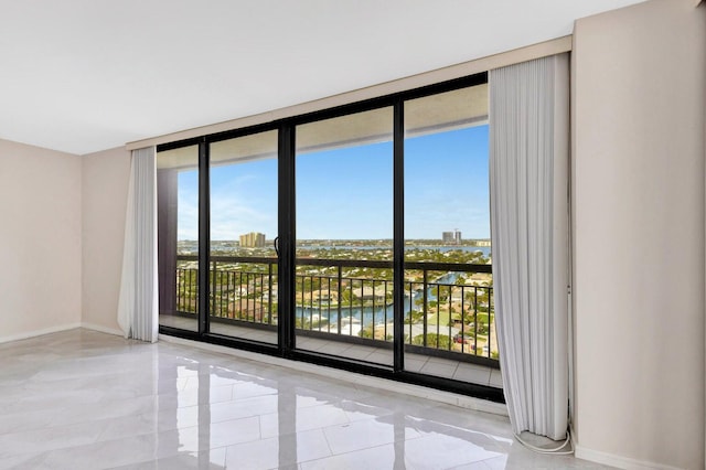 empty room featuring a water view and floor to ceiling windows