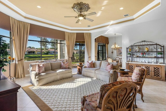 living room with crown molding, a raised ceiling, ceiling fan with notable chandelier, and light tile patterned floors