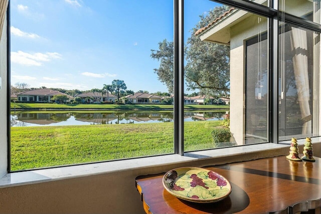 sunroom featuring a healthy amount of sunlight and a water view