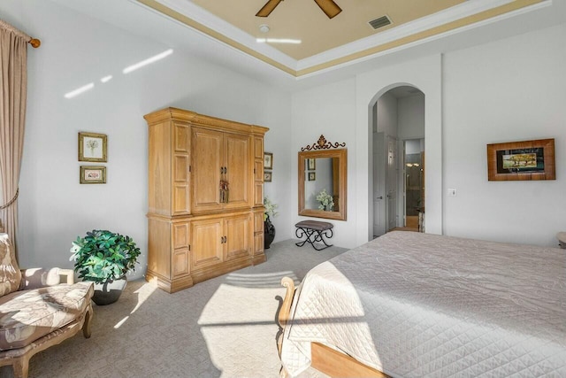 bedroom featuring a raised ceiling, ceiling fan, ornamental molding, and light colored carpet