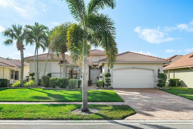 mediterranean / spanish home featuring a garage and a front lawn