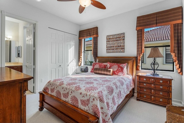 carpeted bedroom featuring ceiling fan, connected bathroom, and a closet