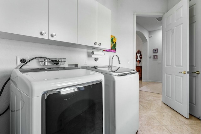 washroom with light tile patterned floors, cabinets, and independent washer and dryer