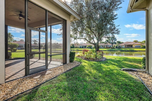 view of yard with a sunroom and a water view