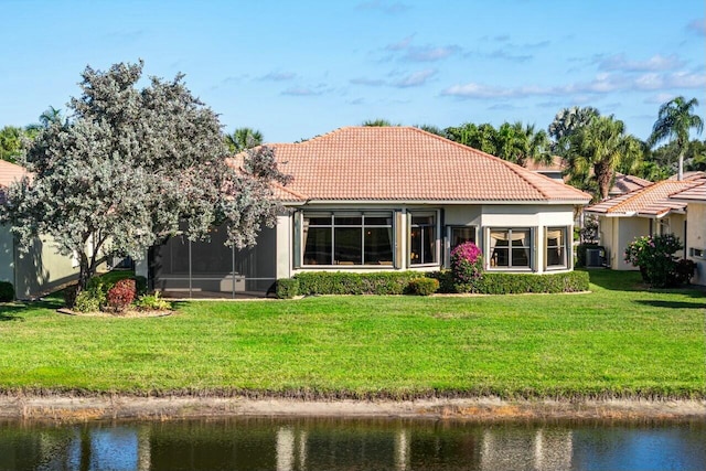 rear view of house featuring a yard, a water view, and central AC unit