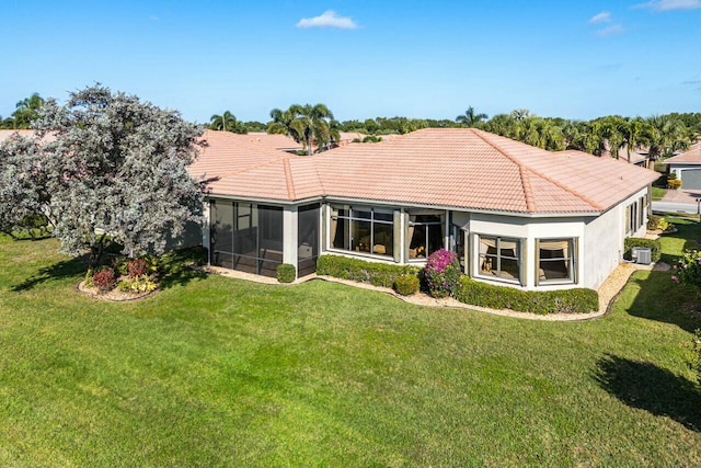 back of house featuring central air condition unit, a lawn, and a sunroom