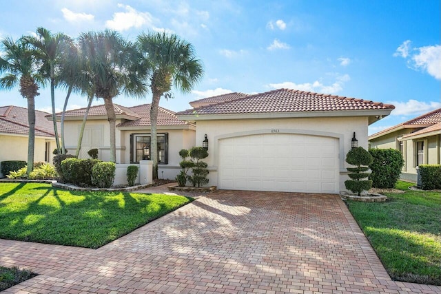 mediterranean / spanish house featuring a front yard and a garage