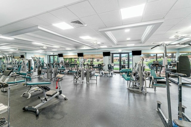 exercise room with a drop ceiling and crown molding