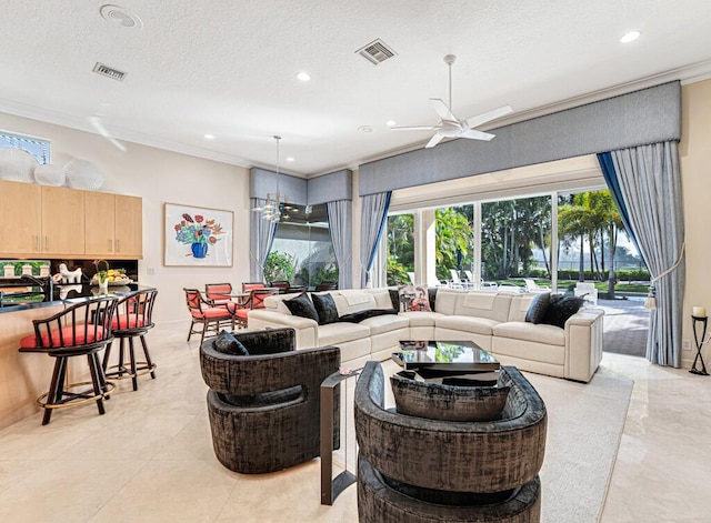 living room with ceiling fan with notable chandelier, ornamental molding, and a textured ceiling