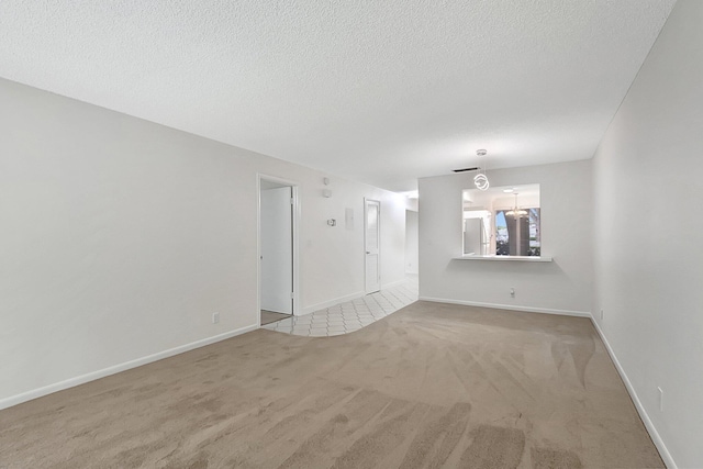 spare room with a textured ceiling and light colored carpet