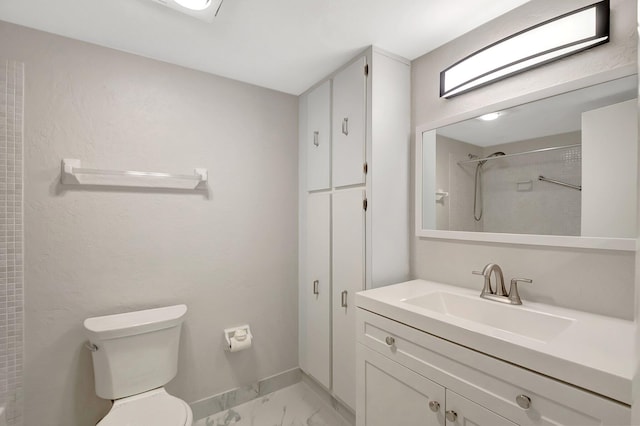 bathroom featuring toilet, a tile shower, and vanity