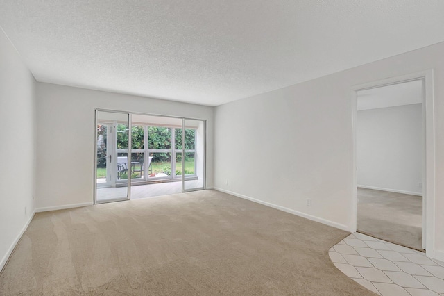 carpeted empty room with a textured ceiling