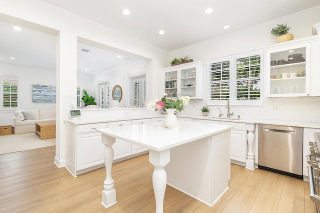 kitchen featuring white cabinetry, backsplash, sink, dishwasher, and a center island