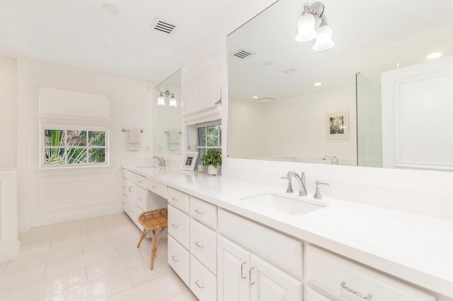 bathroom with a healthy amount of sunlight, tile patterned floors, and vanity