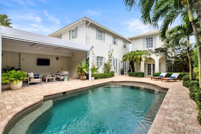 rear view of house featuring an outdoor living space, french doors, and a patio