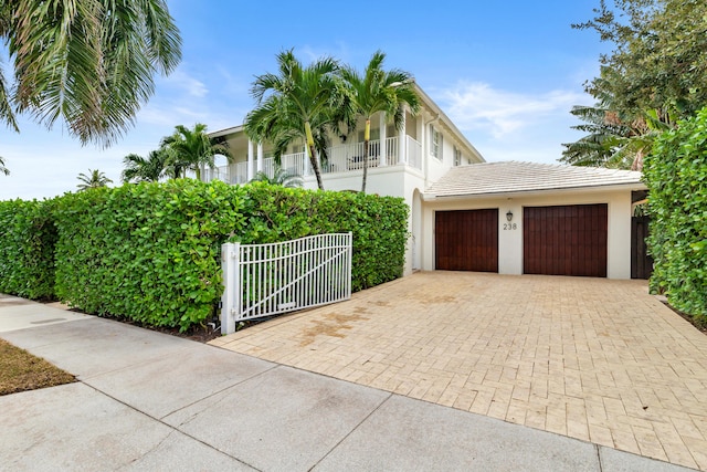 view of side of property featuring a balcony and a garage