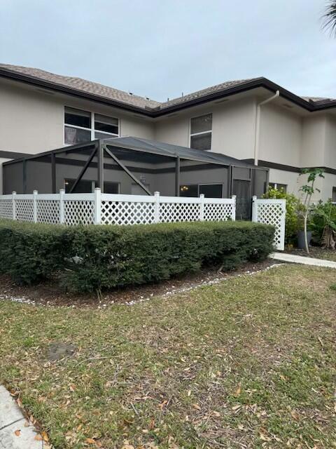 view of side of property with a lawn and a lanai