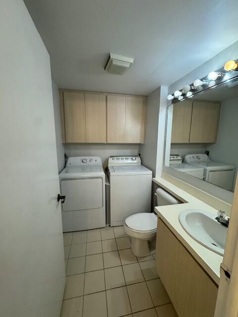 bathroom with tile patterned flooring, sink, and washer and dryer