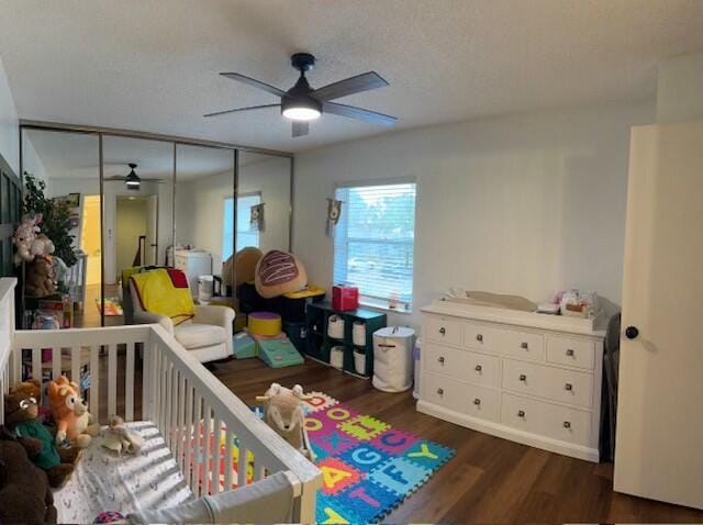 bedroom with dark wood-type flooring, ceiling fan, and a closet