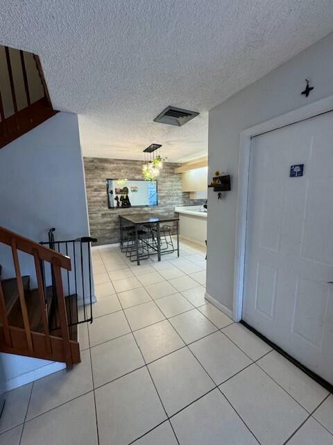 tiled entryway featuring a textured ceiling