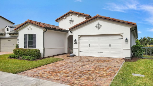 mediterranean / spanish-style home featuring a front lawn and a garage