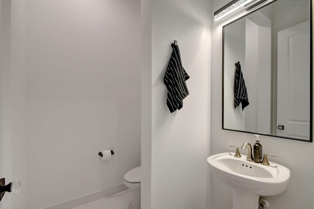 bathroom featuring sink, tile patterned floors, and toilet