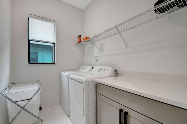 clothes washing area with washer and clothes dryer and light tile patterned floors