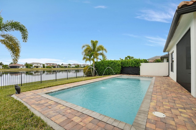 view of swimming pool featuring pool water feature, a yard, and a water view