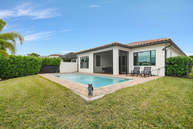 back of house with a yard, pool water feature, a fenced in pool, and a patio area