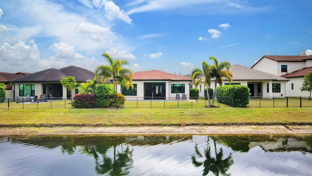 back of property featuring a yard and a water view