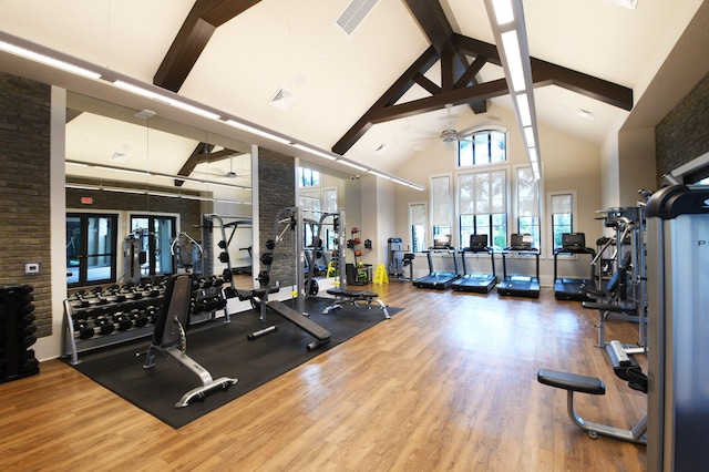 gym with ceiling fan, high vaulted ceiling, and wood-type flooring