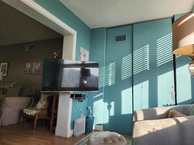 living room featuring hardwood / wood-style flooring and a textured ceiling