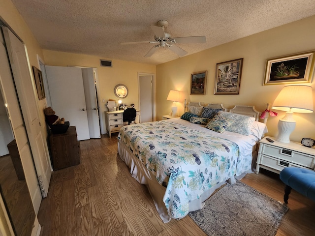 bedroom featuring ceiling fan, a textured ceiling, and wood-type flooring